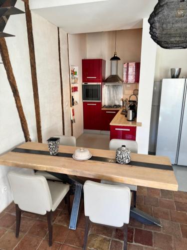 - une cuisine avec une table en bois et des chaises blanches dans l'établissement Appartement tout confort centre historique, à Lavaur