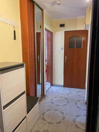 pasillo con puerta y habitación con suelo de baldosa en Apartament w centrum, en Żagań
