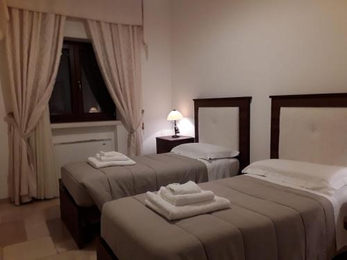 a hotel room with two beds with towels on them at Villa Belvedere in Ostuni