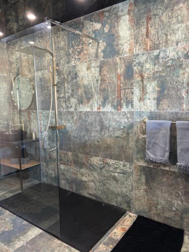 La salle de bains est pourvue d'une douche en verre et d'une serviette. dans l'établissement Studio port nature 1, au Cap d'Agde