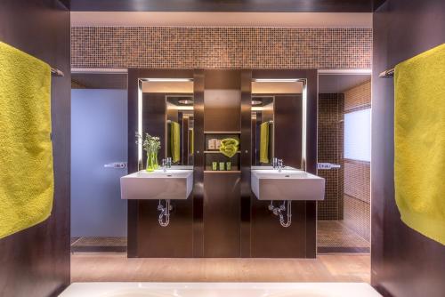 a bathroom with two sinks and two mirrors at Design Chalets Lech in Lech am Arlberg