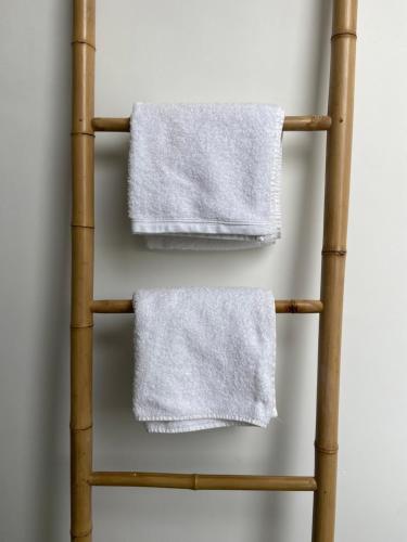 a bamboo towel rack with white towels on it at Le Terracotta - Confort en plein centre in Montaigu-Vendée