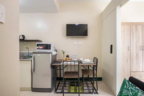 a small kitchen with a table and a refrigerator at WIND RESIDENCES Tagaytay Condo STAYCATION in Silang
