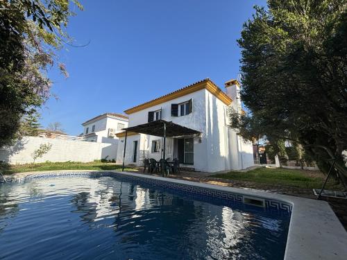 a swimming pool in front of a house at Gran Chalet a 13 min de Sevilla in Gelves