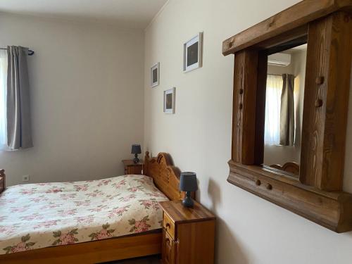 1 dormitorio con cama y espejo grande en Tündér Pension en Mogyoród