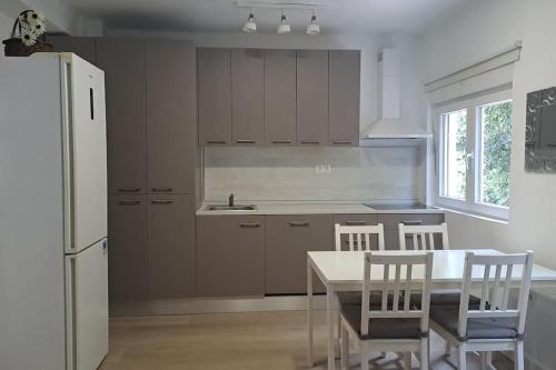 uma cozinha com um frigorífico branco, uma mesa e cadeiras em Acogedor apartamento en el centro em Almeria