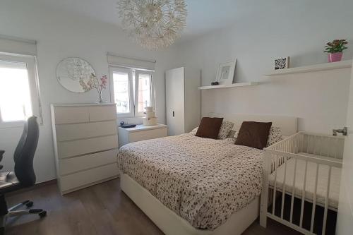 um quarto branco com uma cama e um berço em Acogedor apartamento en el centro em Almeria