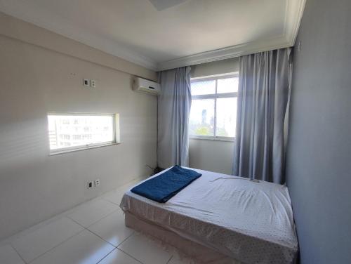 a small bedroom with a bed and a window at 1 Quarto e Sala amplo 47 m2 Vista Mar in Salvador