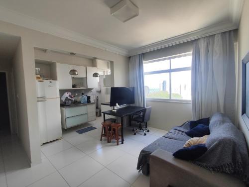 a living room with a couch and a kitchen at 1 Quarto e Sala amplo 47 m2 Vista Mar in Salvador