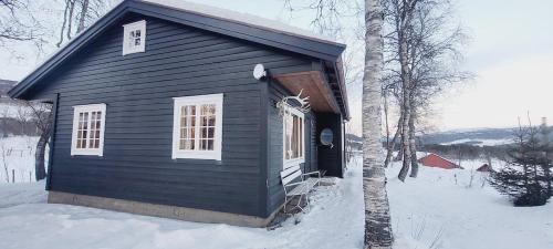 a small black house with snow on the ground at Øen cabin in Geilo by Norgesbooking in Geilo