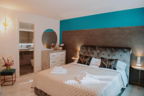 a bedroom with a large bed with a blue wall at La Luce di Sirmione in Sirmione
