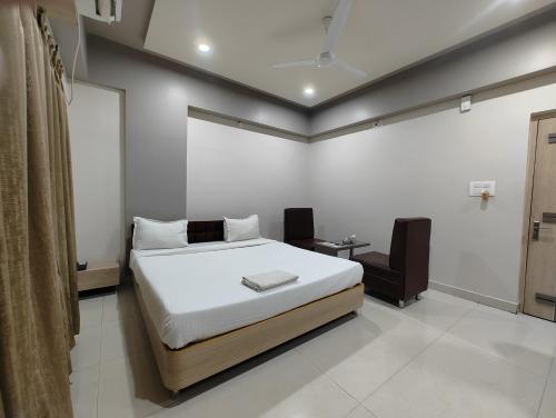 a bedroom with a bed and a chair in it at HOTEL INDRAPRASTHA in Māldah