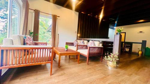 Nature Valley Resort, Lap of Nature Munnar في مونار: غرفة معيشة مع أريكة وطاولة