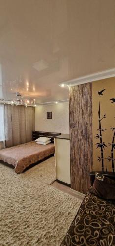 a bedroom with a bed and a wall with birds on it at Апартаменты на СОВЕТСКОЙ 39 in Petropavlovsk