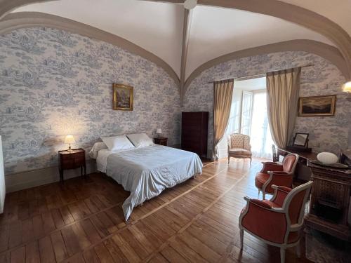 a bedroom with a bed and blue wallpaper at Guest-House Château de Longecourt en Plaine 