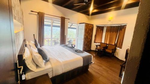 Munnar Tea Estate Hotel and Resort في مونار: غرفة نوم بسرير كبير في غرفة