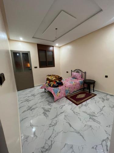 una camera con letto e pavimento in marmo di شقة تتوفر على جميع شروط الراحة و الامان a Benguerir
