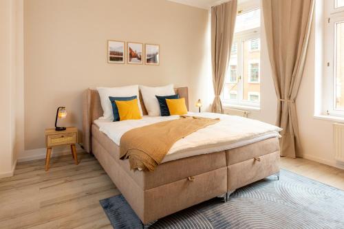 - une chambre dotée d'un grand lit avec des oreillers jaunes et bleus dans l'établissement soulscape Apartments Zwickau EDLER sanierter Altbau-Wohnraum zentrumsnah gratis WIFI, à Zwickau