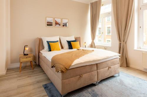 una camera da letto con un grande letto con cuscini gialli e blu di soulscape Apartments Zwickau EDLER sanierter Altbau-Wohnraum zentrumsnah gratis WIFI a Zwickau