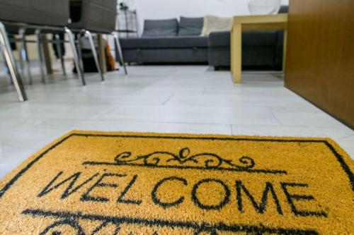a welcome rug on the floor of a living room at A & G Apartment in Bologna