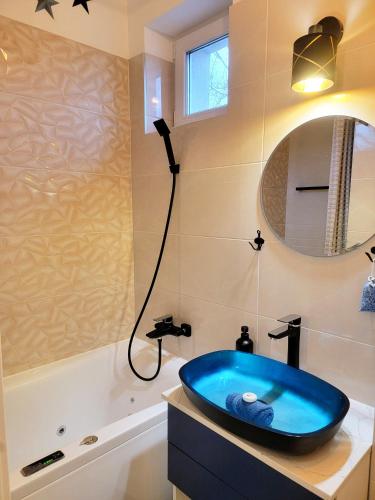 a bathroom with a blue tub and a sink at Moonshine Érd in Érd