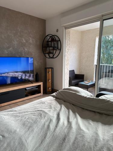 - une chambre avec une grande télévision à écran plat et un lit dans l'établissement Appartement T2 - Vue Montagne, à Biguglia