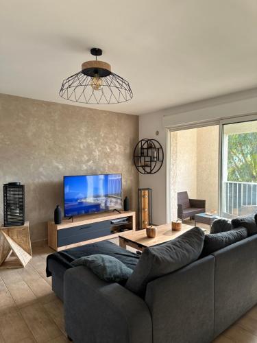 un salon avec un canapé et une télévision à écran plat dans l'établissement Appartement T2 - Vue Montagne, à Biguglia