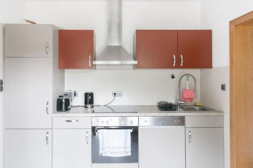 a kitchen with white counters and brown cabinets at Ferienwohnung im Wurmtal 100 qm in Geilenkirchen