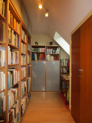 einen Flur mit Bücherregalen und einer Tür in der Unterkunft Deckerveillant chambres près de la mer in Plozévet
