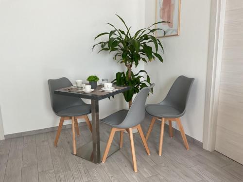 una mesa de comedor con 4 sillas y una planta en Climy, en Sestu