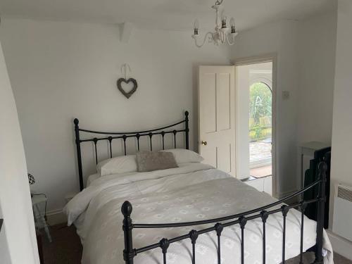 a bedroom with a bed with a black frame at The Brick House, cosy cottage in North Cornwall in Saint Teath
