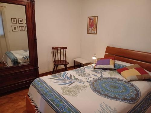 a bedroom with a bed and a mirror and a chair at casa il Girasole Pitigliano in Pitigliano