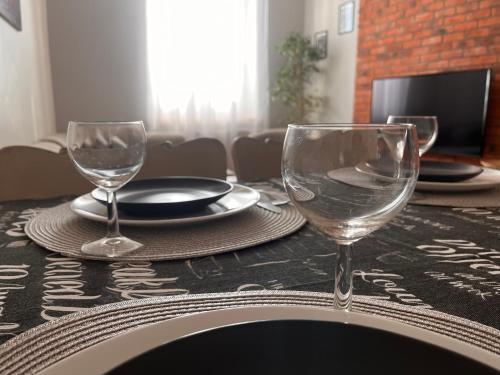 una mesa con dos copas de vino encima en Zamkowy Apartament, en Lublin