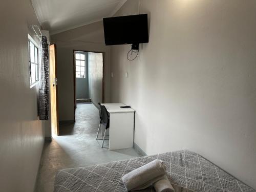 een kamer met een bed en een televisie aan de muur bij Southernwood nest in East London