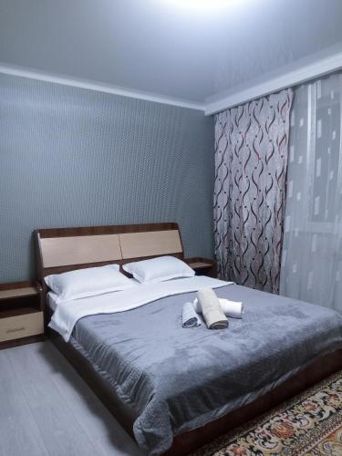 a bedroom with a bed with two towels on it at Уют в сердце Алматы in Almaty