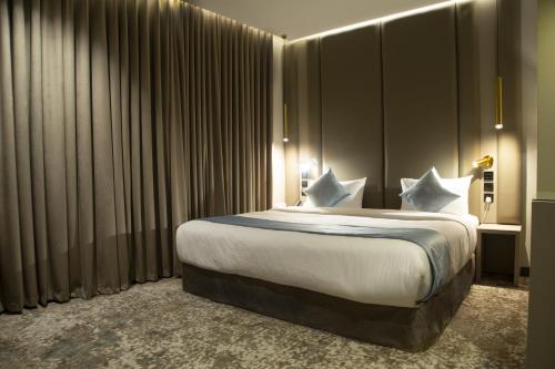 a hotel room with a large bed with white sheets at فندق راسيا المدينة المنورة in Al Madinah