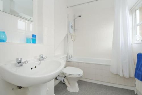 a white bathroom with a sink and a toilet at Zone 1! 2 bed duplex Apartment! in London