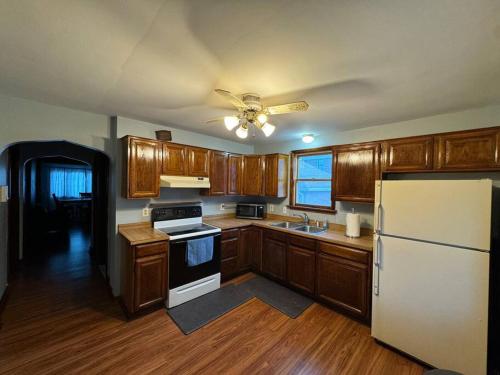 a kitchen with wooden cabinets and a white refrigerator at Comfy getaway at falls! in Niagara Falls