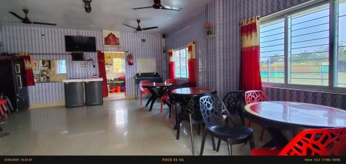 a dining room with tables and chairs in a restaurant at India Tours only Ekanta Apan in Mathurakhanga