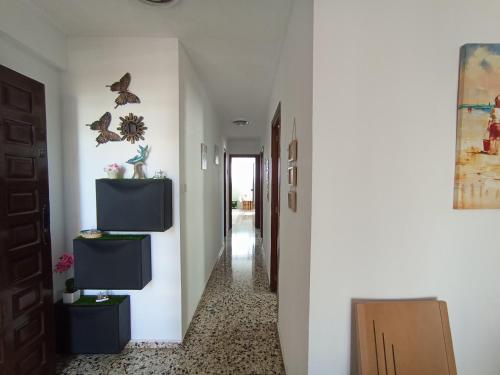 a hallway with a white wall with a tv on it at APARTAMENTO 3 PAUPÍ in Oliva