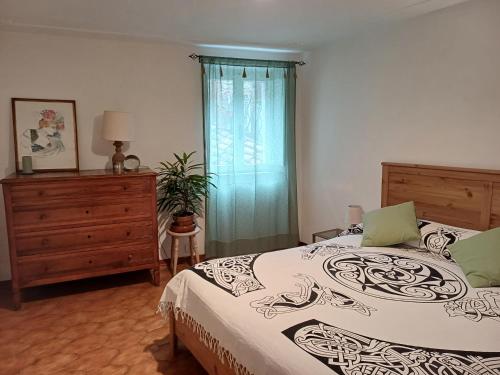 a bedroom with a bed and a dresser and a window at casa il Girasole Pitigliano in Pitigliano