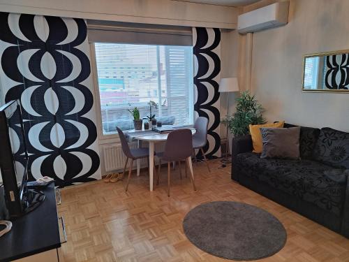 uma sala de estar com uma mesa e um sofá em Saunallinen yksiö em Pieksamaki