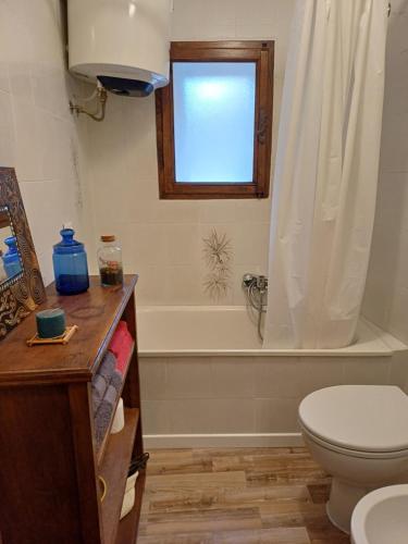 a bathroom with a tub and a toilet and a window at casa il Girasole Pitigliano in Pitigliano