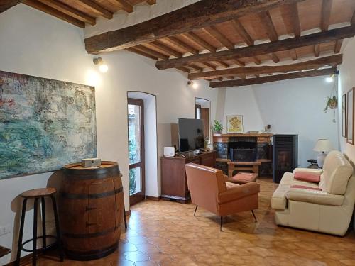 a living room with a barrel and a couch and chair at casa il Girasole Pitigliano in Pitigliano