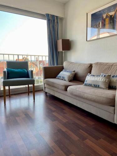un salon avec un canapé et une chaise dans l'établissement Appartement 2 chambres proche mer & centre-ville av wifi, à Le Touquet-Paris-Plage