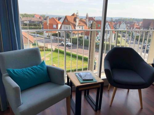 - un salon avec une chaise, une table et une fenêtre dans l'établissement Appartement 2 chambres proche mer & centre-ville av wifi, à Le Touquet-Paris-Plage