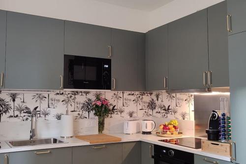 a kitchen with gray cabinets and a vase of flowers at Maison cosy terrasse ensoleillé in Clermont-Ferrand