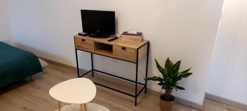 a small table with a tv and a chair in a room at Studio Laval in Laval