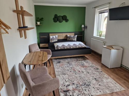 een slaapkamer met een bed en een tafel en stoelen bij Penzion u Jezevce in Hřensko