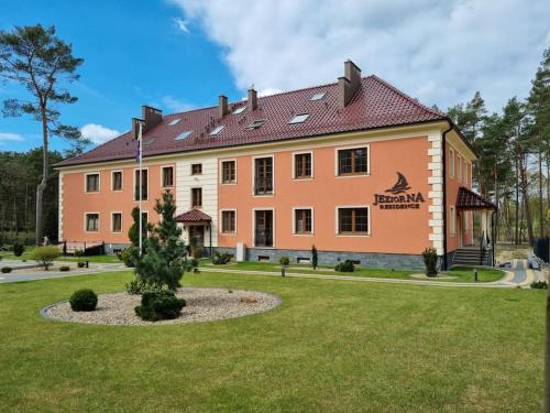 a large building with a garden in front of it at Uroczy apartament blisko jeziora in Borne Sulinowo